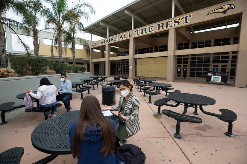 Liliana Castro, high school advisor, front, and Hector Navarette, assistant director, both with UCR’s Educational Talent Search, meet with students about applying to colleges on Thursday, October 7, 2021, at Arroyo Valley High School in San Bernardino. UC Riverside’s Educational Talent Search, San Bernardino grant was recently renewed for five years for $1,642,065. 